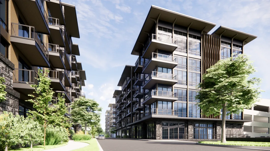 A modern urban apartment complex with multiple stories, featuring large windows and balconies. The buildings are surrounded by trees and lush greenery, with a clear blue sky in the background. A road runs between the buildings.