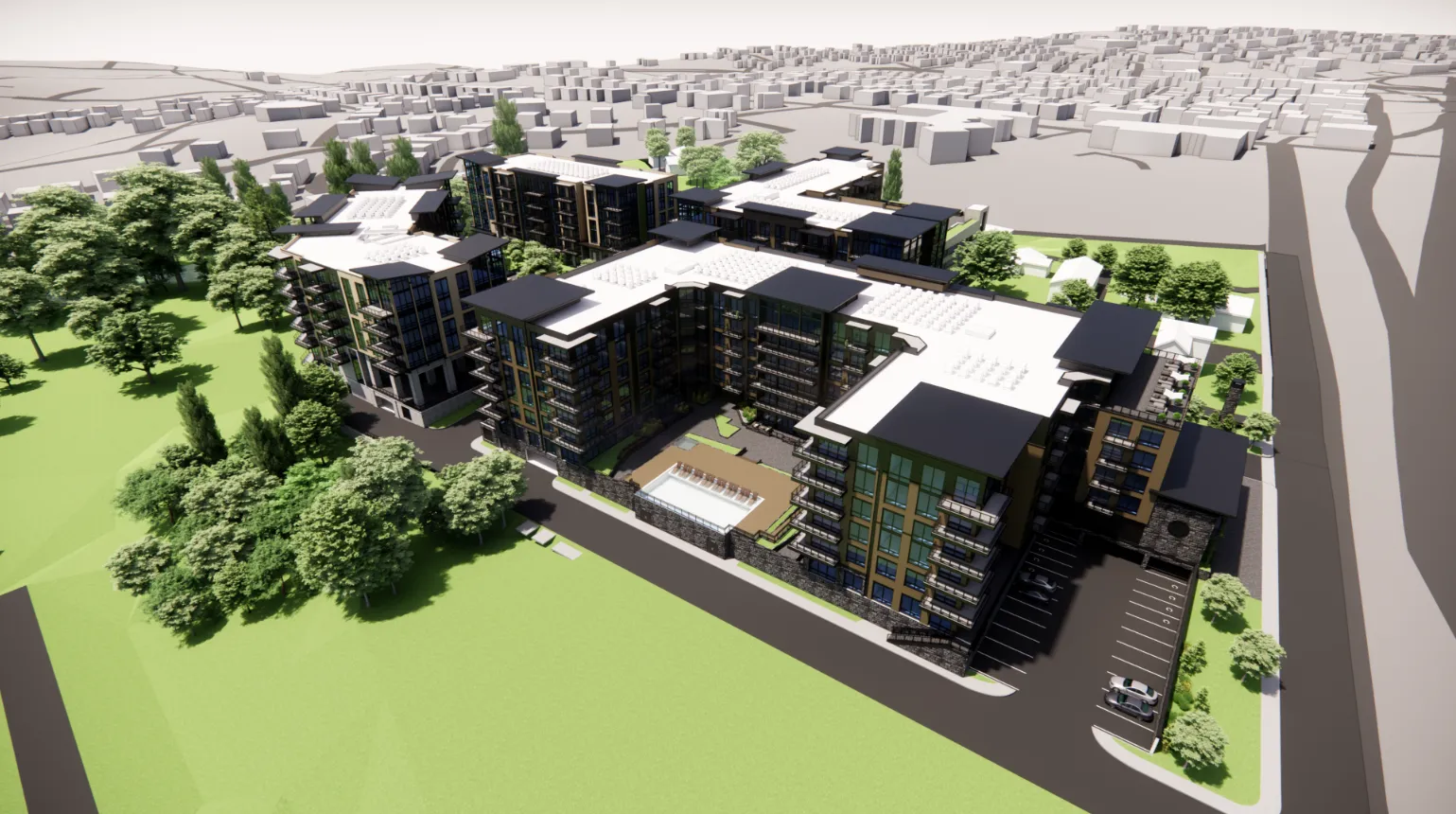 Aerial view of a modern apartment complex with multiple buildings surrounding a central courtyard. The area features green spaces and pathways. Nearby, residential houses and roads are visible, with a sprawling cityscape in the background.